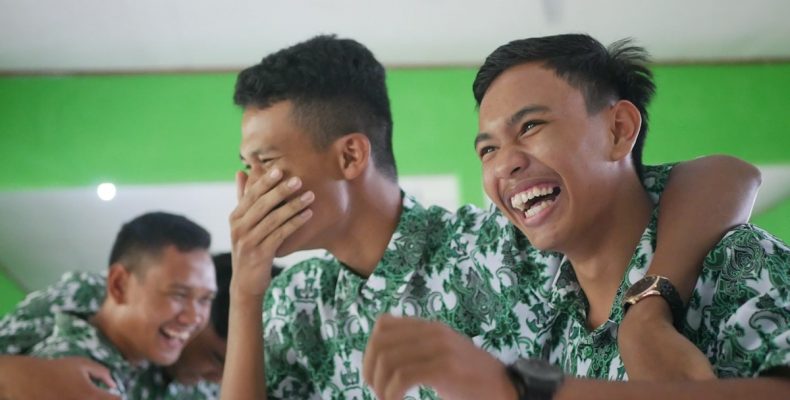 a couple of men sitting next to each other